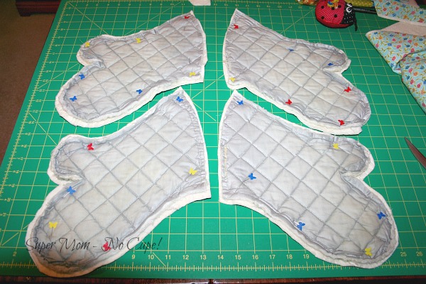 https://www.supermomnocape.com/wp-content/uploads/2015/11/Quilted-fabric-cut-to-fit-old-oven-mitts.jpg