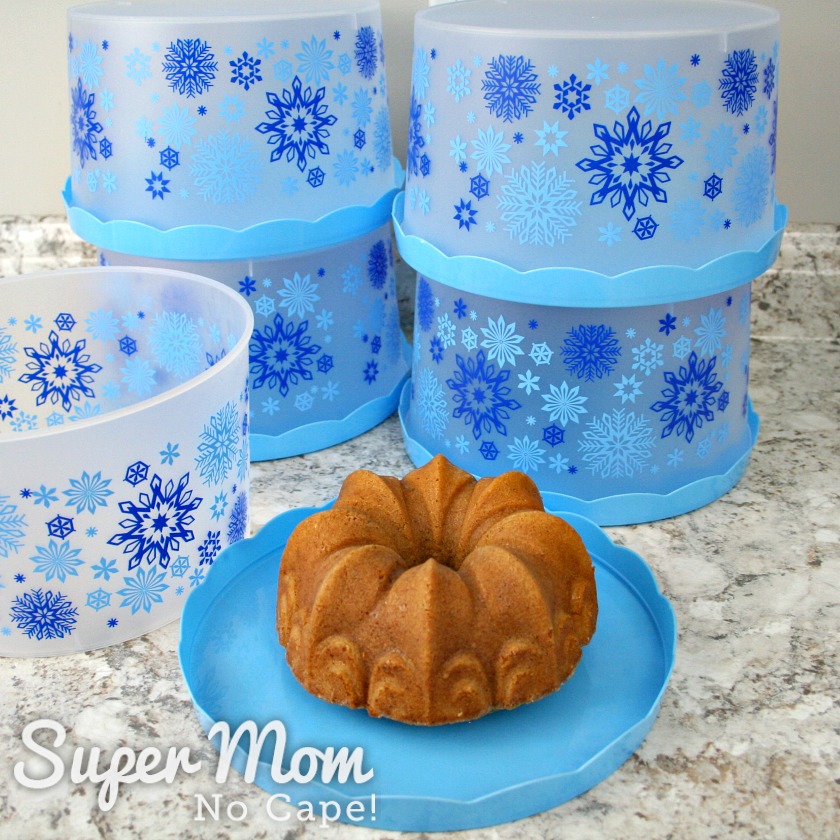 Bundt cake on lid of cake container with 4 containers in the background