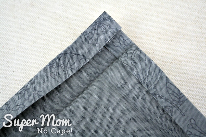 One inch pressed seam opened to reveal creases to make the mitered corners on the napkin.