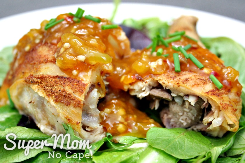 Baked chicken leg cut in half topped and placed on a bed of salad greens topped with Homemade Orange Sauce