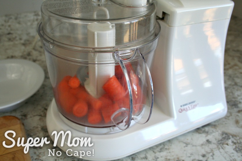 Coursely chopped carrots in the bowl of a food processor