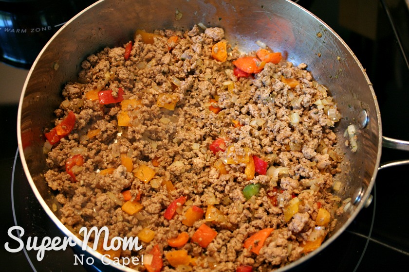 Sausage meat mixture for stuffed zucchini pizze boats cooking in a frying pan