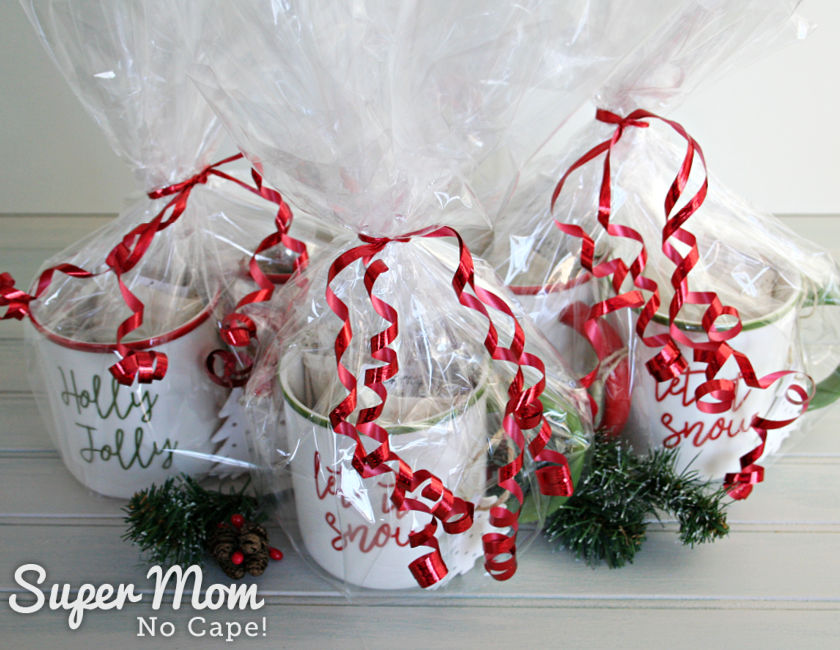 A picture of tea mugs with loose leaf tea in bags inside wrapped in cellophane and tied with decorative ribbon